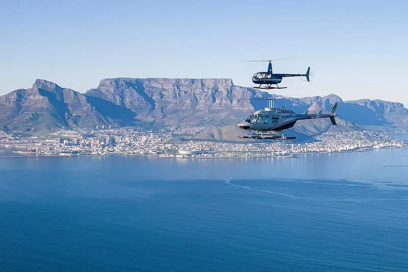A helicopter flies above the coast of False Bay near Cape Town.