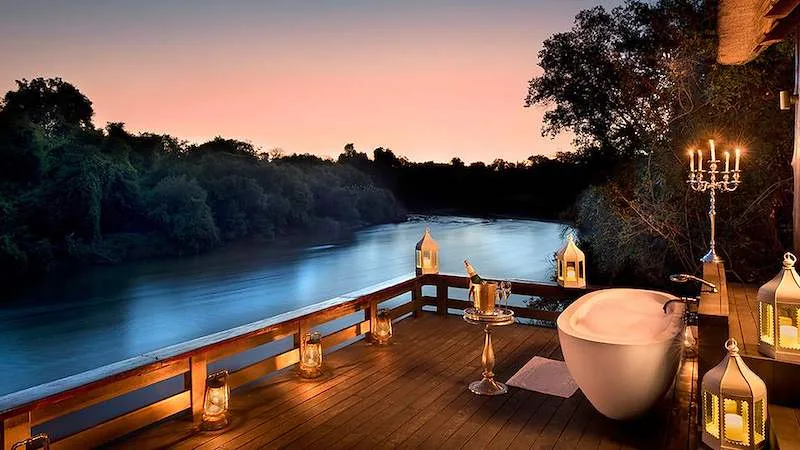 A candlelit deck at Royal Chundu sits above the Zambezi River.