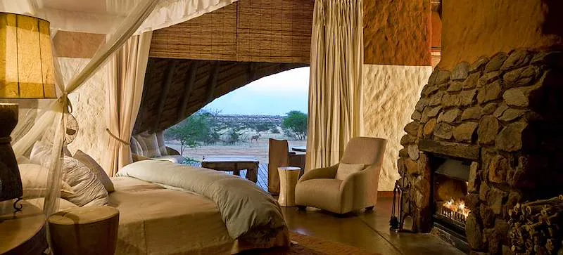 A guest suite at Tswalu opens onto a stone terrace and the Kalahari landscape.