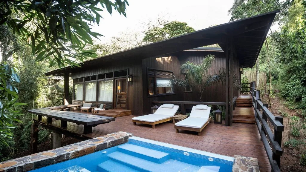 A private plunge pool framed by timber at a rainforest villa.