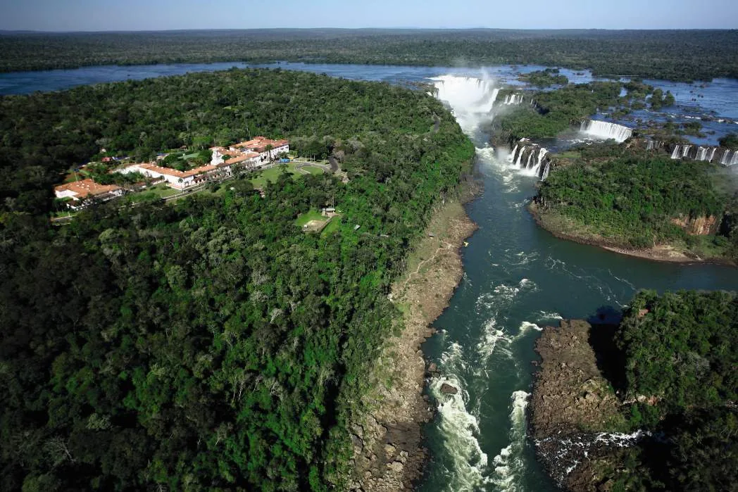 Aerial view of Iguazú Falls cutting through subtropical forest.