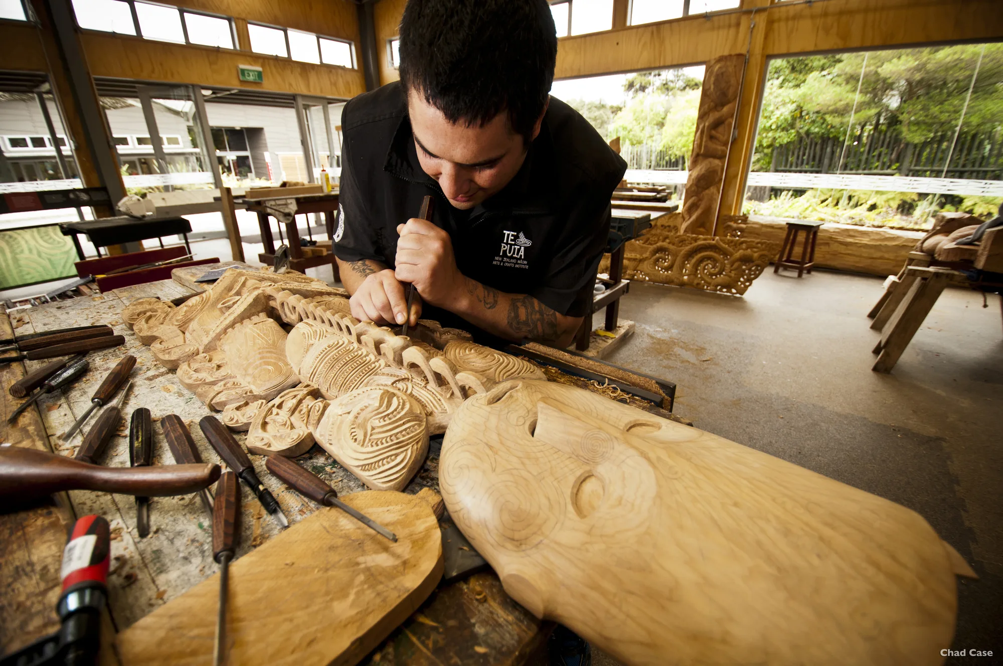 A craftsperson carves a wooden sculpture by hand.