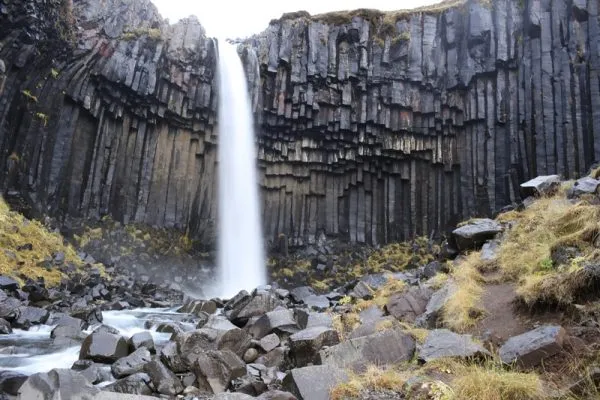 A waterfall dropping over dark basalt columns on Iceland’s south coast.