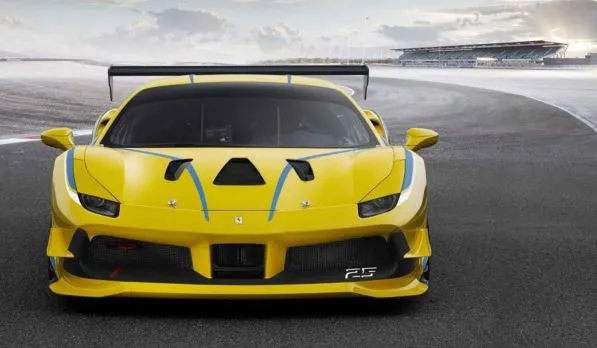 A yellow Ferrari positioned on an asphalt racetrack.