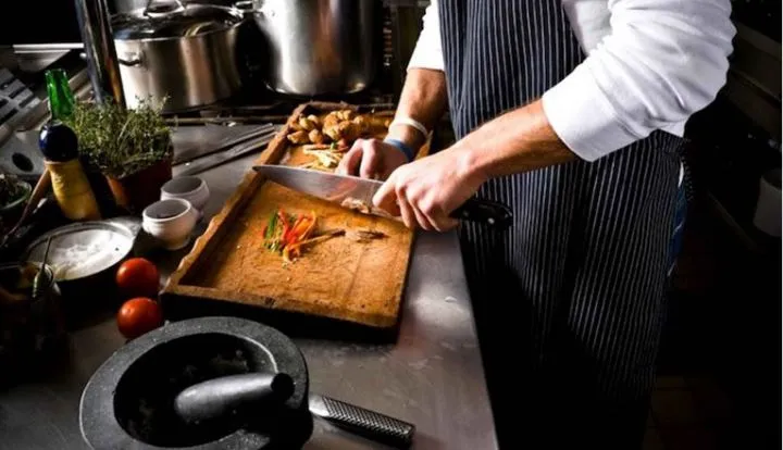 A chef preparing ingredients at a kitchen counter.