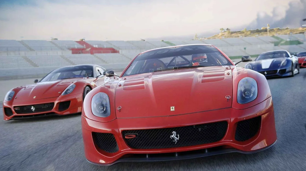 Red sports cars lined up on a race track with another blue car behind them.