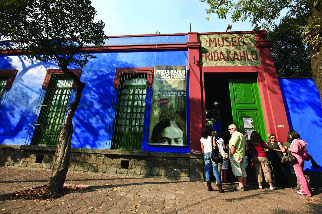 Visitors outside the vivid blue and red entrance to Museo Frida Kahlo.