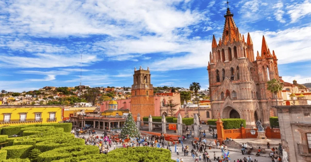 A pink church overlooking the gardens and colourful buildings of San Miguel de Allende.
